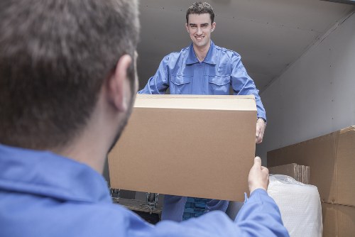 Professional movers organizing office equipment in storage
